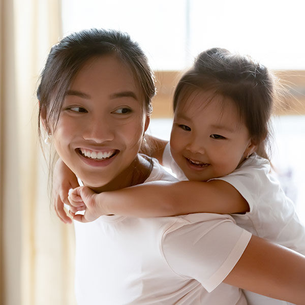 Mother and Daughter smiling in front of a window Mother and Daughter smiling in front of a window